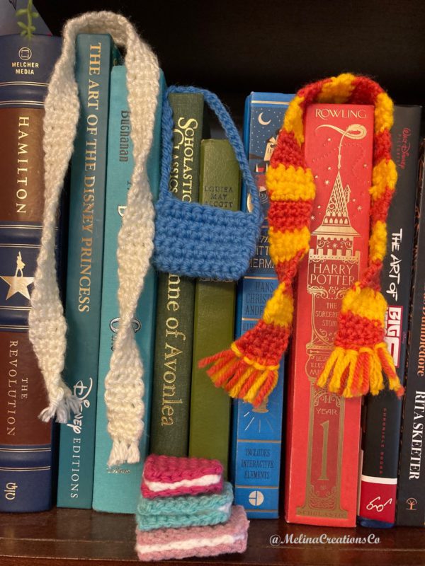 Crochet scarves, books, purse on bookshelf
