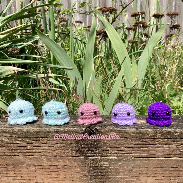 Octobuddy keychains lined up in a garden